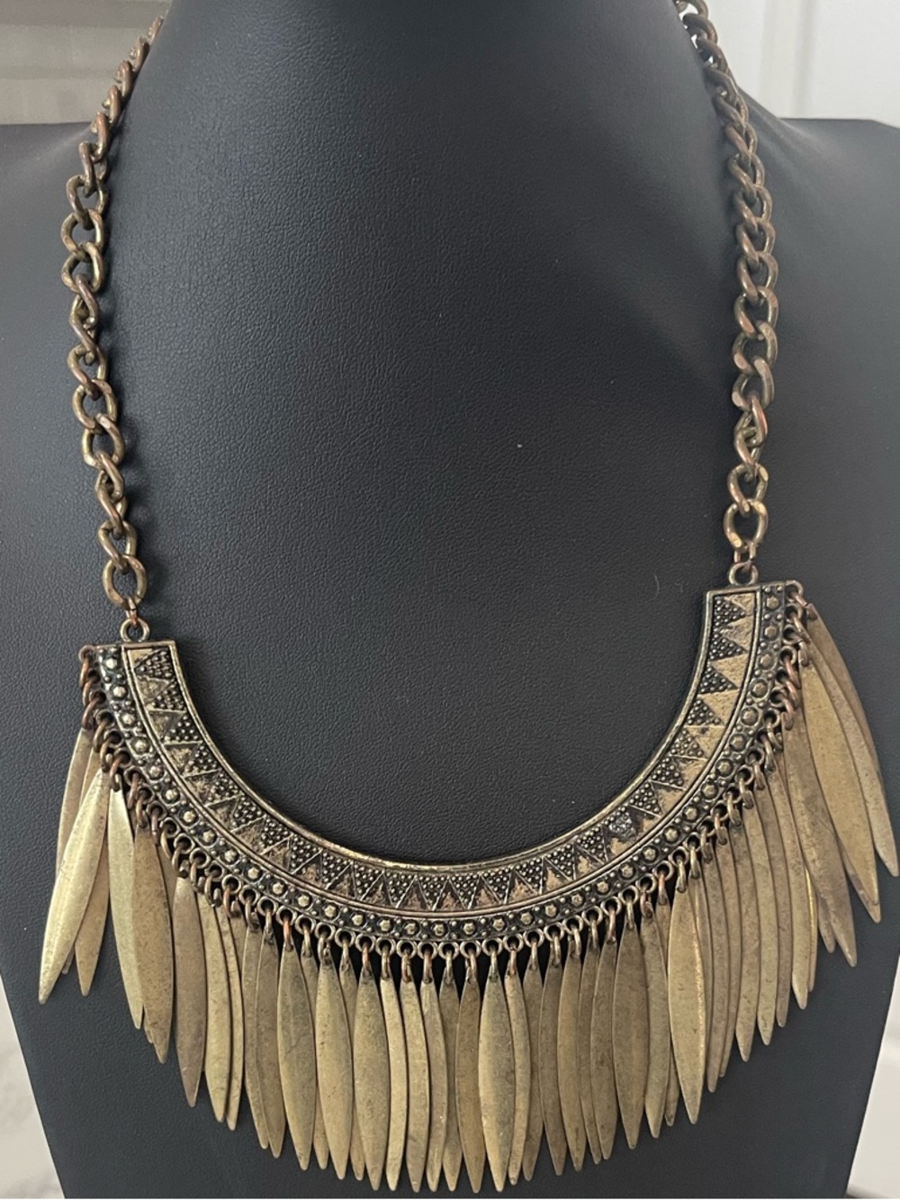 Antique gold bib statement necklace featuring a dramatic fringe design.